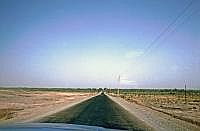 Strae nach Kashgar: Im Hintergrund erscheint die Oasenstadt Kashgar. Sie war ein wichtiger Knotenpunkt der Seidenstrae. Die Stadt Sie liegt am Rande des Tarimbeckens in 1235 bis 1300 m .d.M. Die Bevlkerung ist vorwiegend uigurisch und somit islamisch geprgt. Die chinesische Regierung fhrt zur Zeit eine umfangreiche 