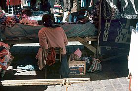 Cuzco: Kind in der Kiste unter dem Marktstand