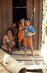 Frau mit Kindern vor ihrem Haus in Long Apari