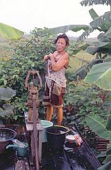 Pinang Habang: Frau wscht sich an einer Wasserpumpe