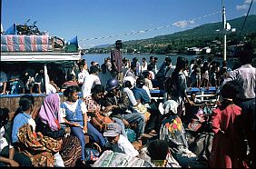 Menschen im Boot und am Fähranleger Waiwerang