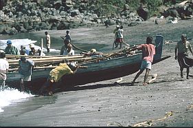 ein Walfangboot wird im Hafen von Lamalera auf den Strand gezogen