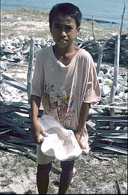 Junge mit groer Muschel, die zur Salzgewinnung  genutzt wurde