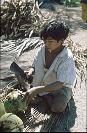 Junge ffnet mit Messer eine Kokosnuss