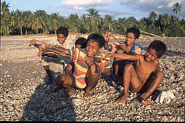 Jungen mit Fletschen am Strand bei Seba