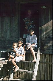 Drei Jungen sitzen auf der Leiter vor ihrem Haus in Jatibaru