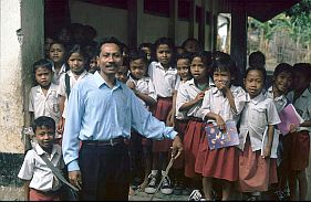 Lehrer mit seiner Klasse vor der Schule in Kolo