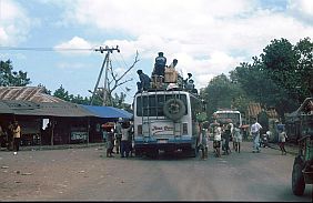 Kinder verkaufen Erdnsse an die Fahrgste an der Busstation in Taloko