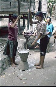 Zwei junge Mdchen stampfen Reis