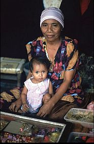 Marktfrau mit Kleinkind an ihrem Stand