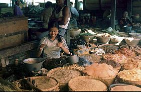 Junge Frau an ihrem Stand mit Reiscrackern und diversen Krnern