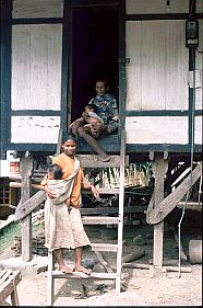 Zwei Frauen mit kleinen Kindern auf der Treppe vor ihrem Haus