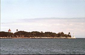 Dili: Blick auf die Hafeneinfahrt mit Leuchtturm und Motael-Kirche