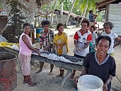 Numfor:  Manggari: Herstellung von Kokos-l. Kopra wird gepresst und gewssert, dann in ein groes Fass abgefllt. Nach einiger Zeit schwimmt das l auf dem Wasser und wird abgeschpft.