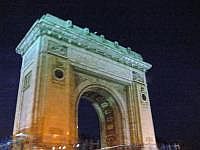 Bukarest bei Nacht: Triumphbogen
Der heutige Arcul de Triumf (Triumphbogen) wurde zu Ehren des Triumphes im Ersten Weltkrieg errichtet. Die Geschichte des Triumphbogens ist nicht uninteressant. 1878, nach Erlangung der Selbstndigkeit des Landes, errichtete man am Ende der Kiseleff-Avenue ein provisorisches Monument. Dieses Bauwerk wurde 1922 durch ein greres, aber immer noch provisorisches aus Holz und Stuck ersetzt - woraufhin der berhmte rumnische Musiker und Komponist George Enescu einen spttischen Brief an den Brgermeister mit der Frage schrieb, wann denn die Hauptstadt einmal einen echten Triumphbogen erhalten werde. Besagter „dauerhafter“ Triumphbogen wurde dann 1935 bis 1936 von Petre Antonescu zu einem riesigen Bauwerk nach klassisch-rmischer Art vollendet und zum Nationalfeiertag am 1. Dezember 1936 eingeweiht - ein Beispiel dafr, dass jahrzehntelange bombastische Provisorien in Bukarest durchaus Tradition haben. Der Arcul de Triumf ist mit zahlreichen Eintragungen und bemerkenswerten Reliefs verziert. Bekannte Bildhauer, wie Frederick Storck Ion Jalea, Cornel Medrea und haben zur Fertigung dieses Denkmals beigetragen. Wie in Paris strmt auch hier der Verkehr von einer Reihe groer Straen sternfrmig auf den mchtigen Bogen zu. (Quelle: wikipedia)