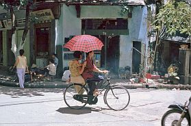Hanoi: Radfahrer mit Sonnenschirm